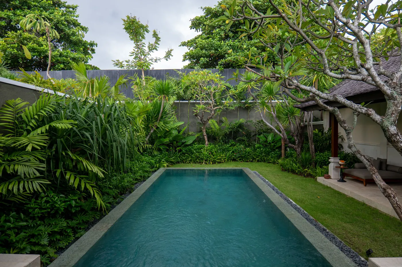 Long private villa pool set in a lush walled garden