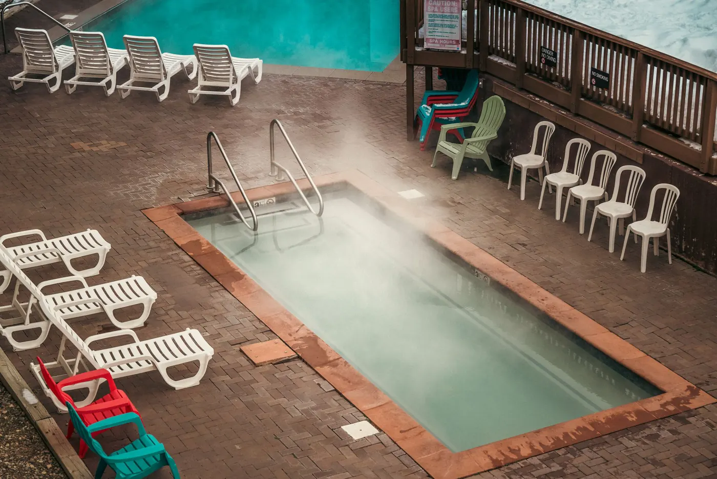 Steam rising off a heated outdoor pool surrounded by snow