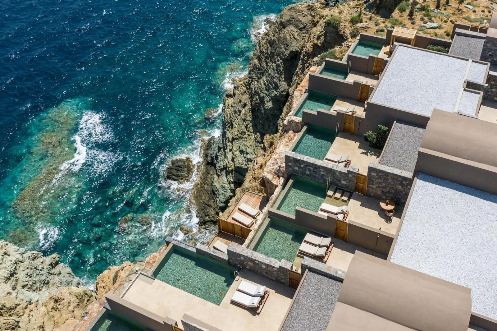 Aerial view of Acro Suites stepping down the cliff, private pools on each terrace