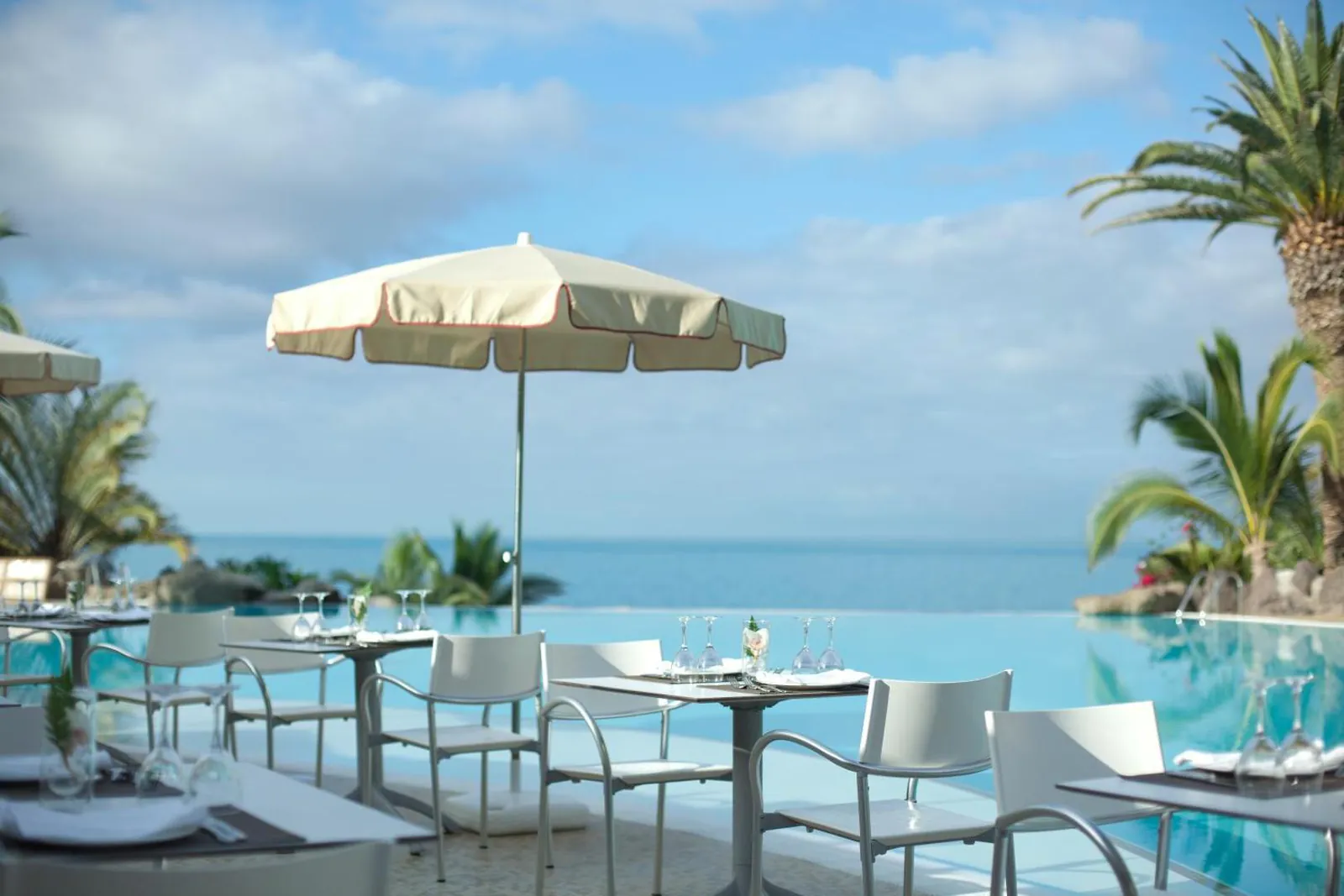 Parasol-shaded tables beside the infinity pool