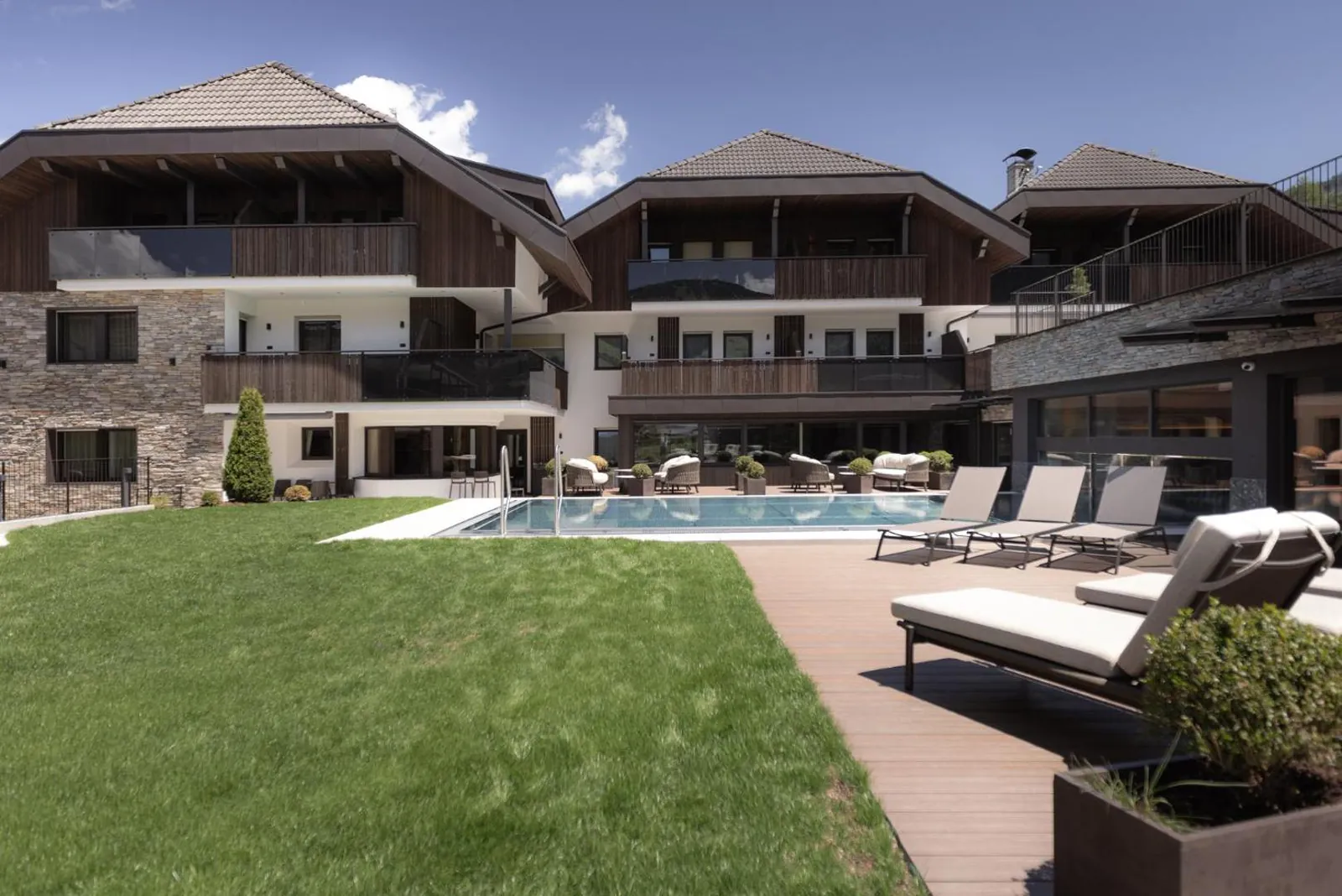 Aparthotel Familiaris buildings above a lawn and outdoor pool