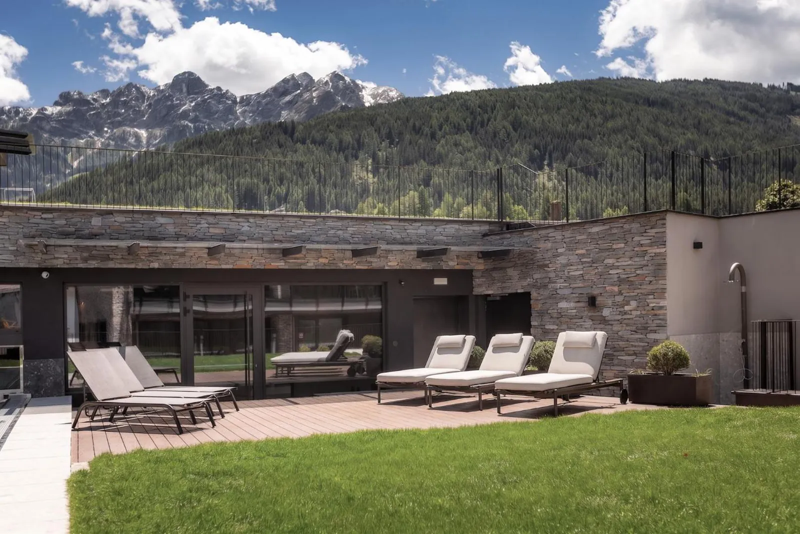Loungers on a terrace between the pool and the lawn
