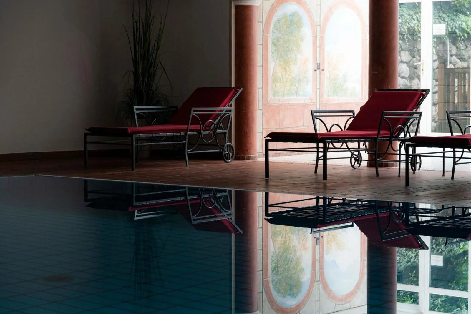 Loungers beside the indoor pool, with stained-glass windows behind