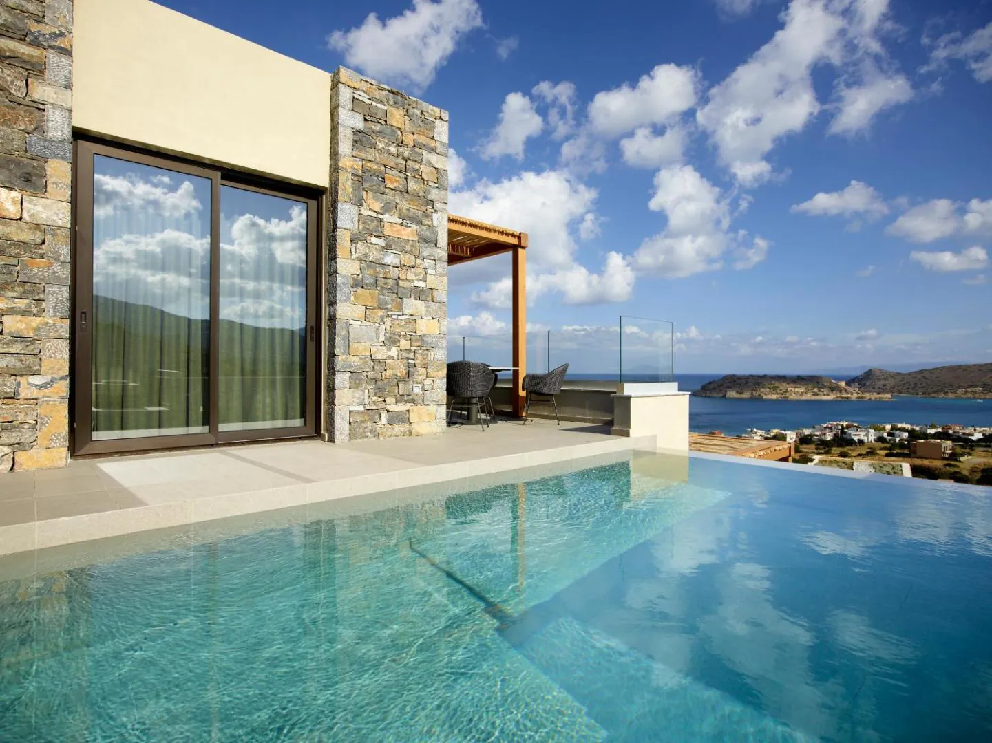 Private infinity pool in front of a stone-walled suite