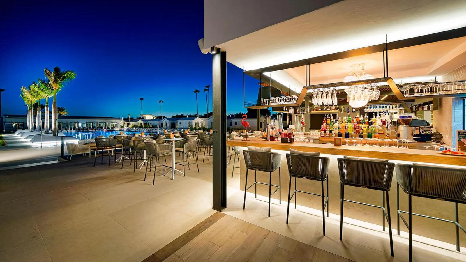 Poolside bar counter with stools at dusk