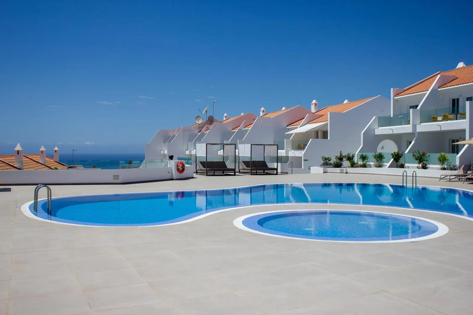 Main pool and round kids' pool in front of the white apartment blocks