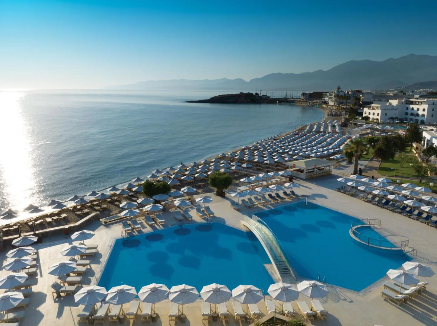 Two large pools above the long beach at Creta Maris, with Hersonissos bay behind