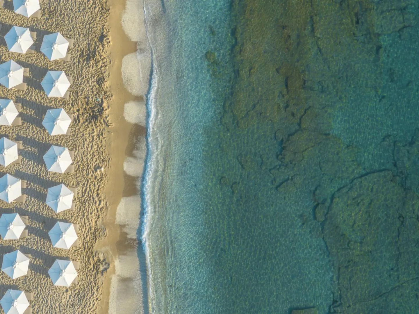 Aerial view of the beach with rows of umbrellas and turquoise water