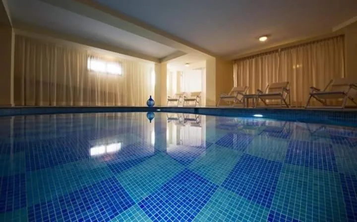 Indoor pool seen at water level with a chequered tile floor