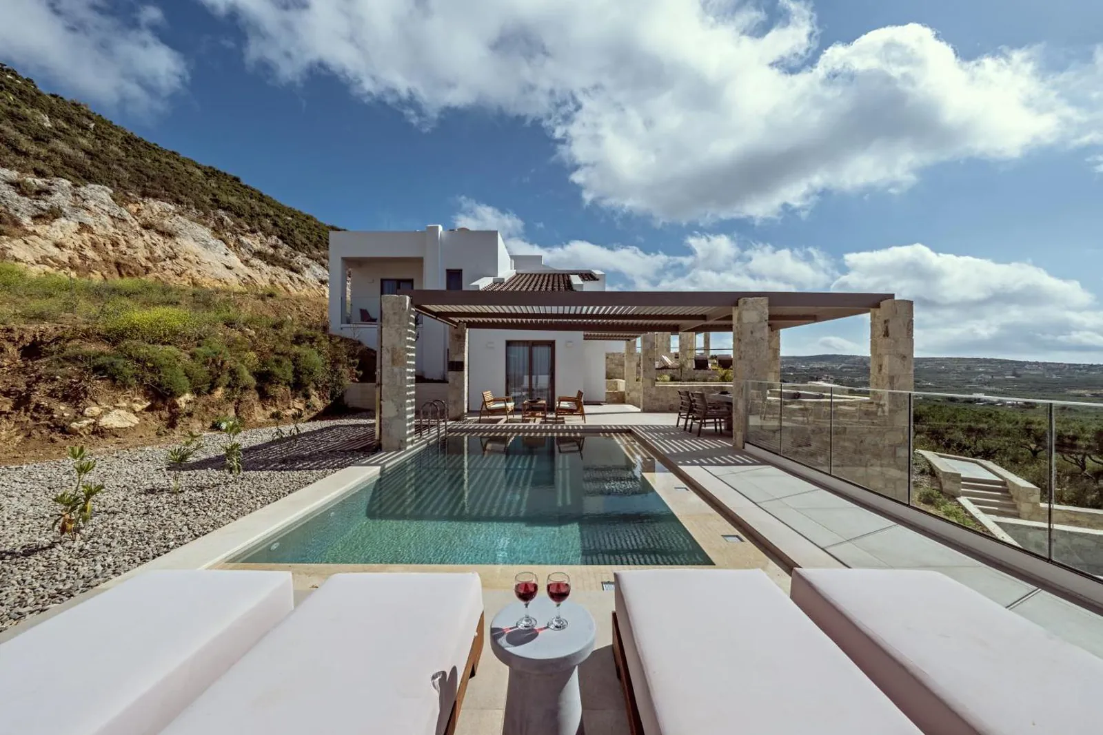 Private pool at Ethereal White Villas with the white villa, pergola and hills behind