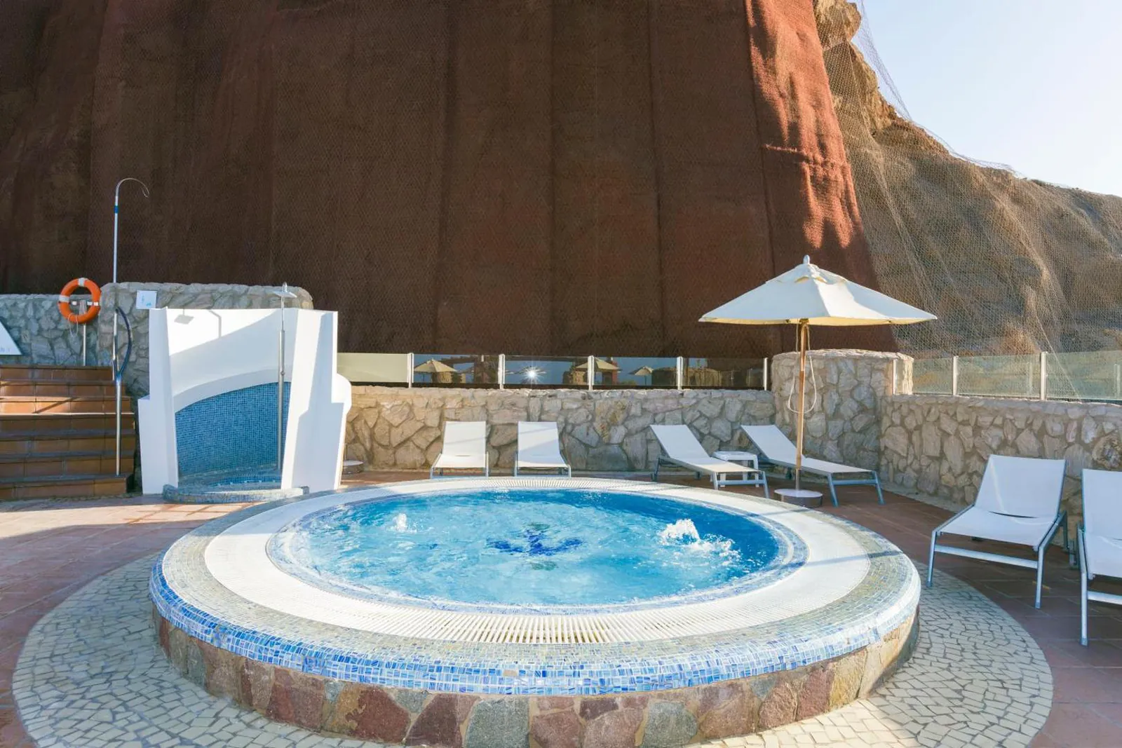 Round whirlpool on a terrace below the red cliff