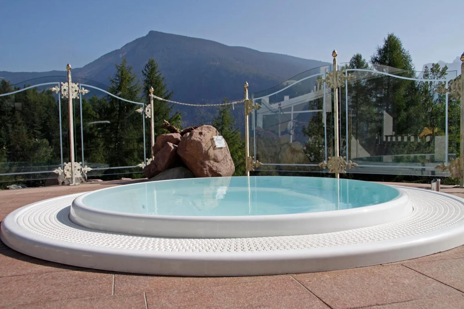 Round outdoor whirlpool on a terrace with mountain views