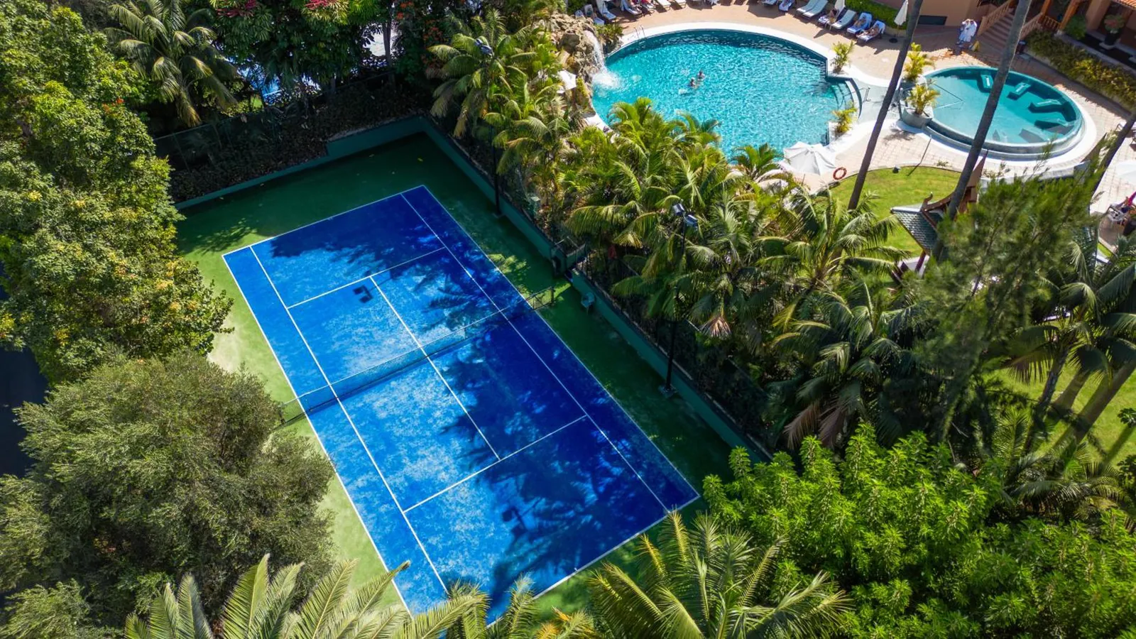 Aerial view of the gardens with a tennis court and outdoor pools