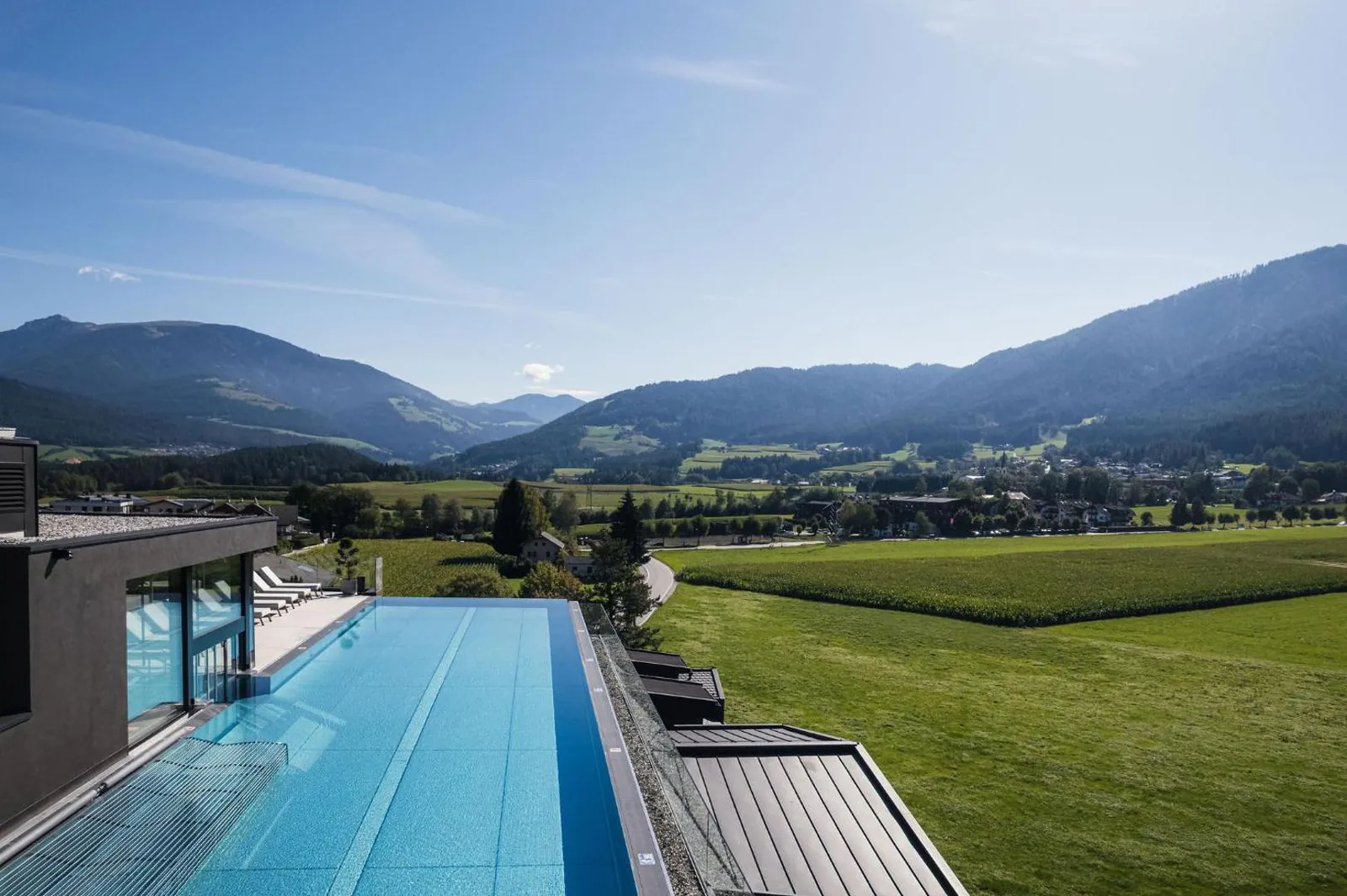 Long outdoor pool at Hotel Majestic with a view over green valley and mountains