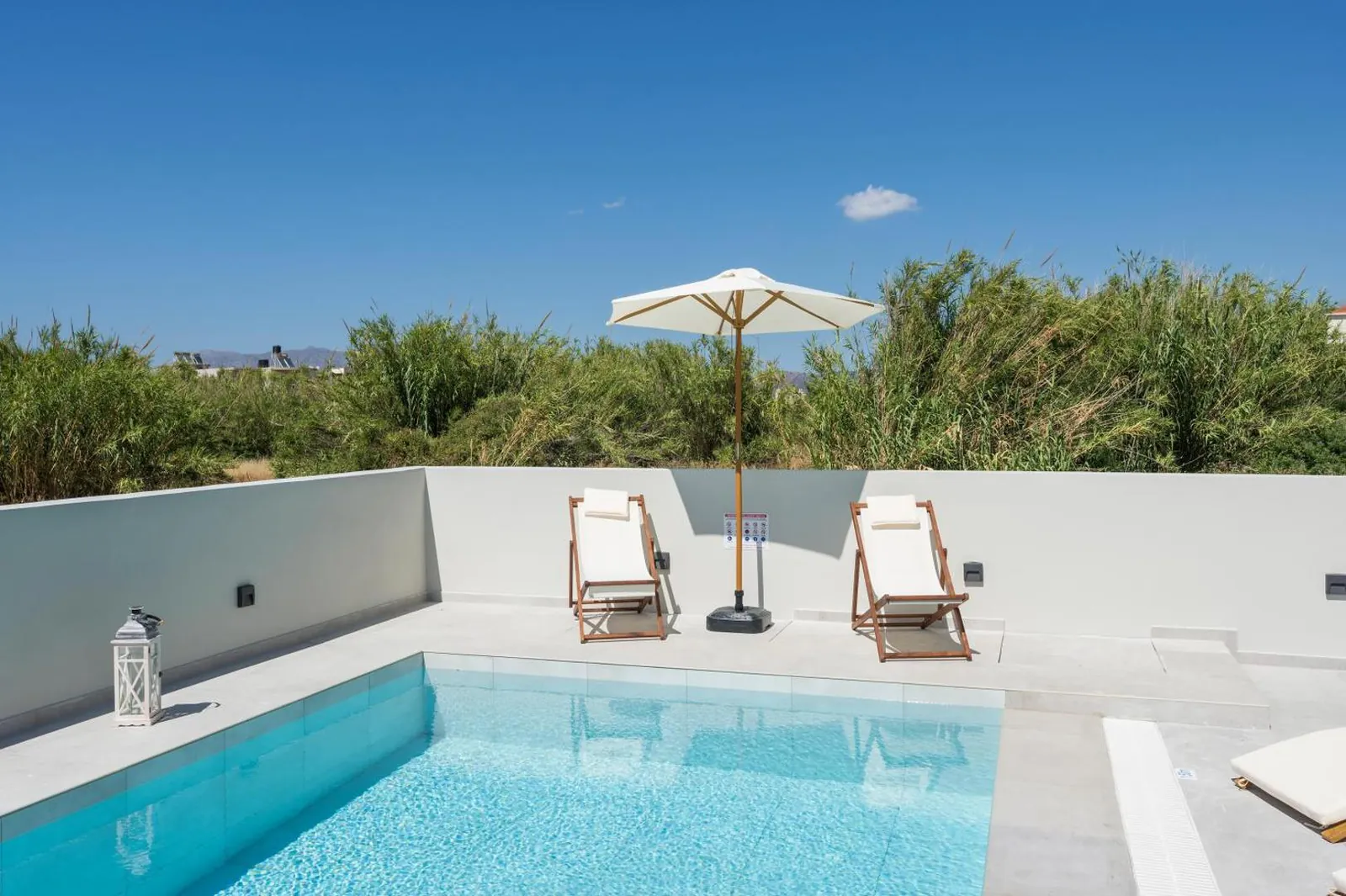 Small pool corner with two deckchairs and a parasol