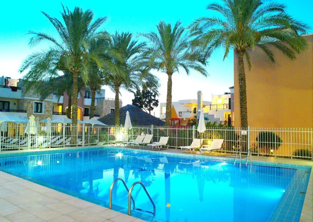 Outdoor pool framed by tall palms in the garden at Kallitsakis Beach