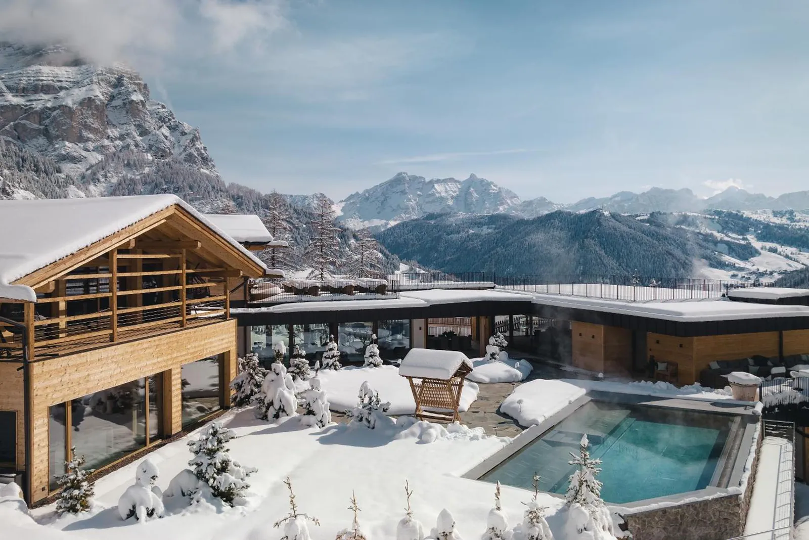 Outdoor pool beside the chalet wing with snow-covered terraces at Kolfuschgerhof