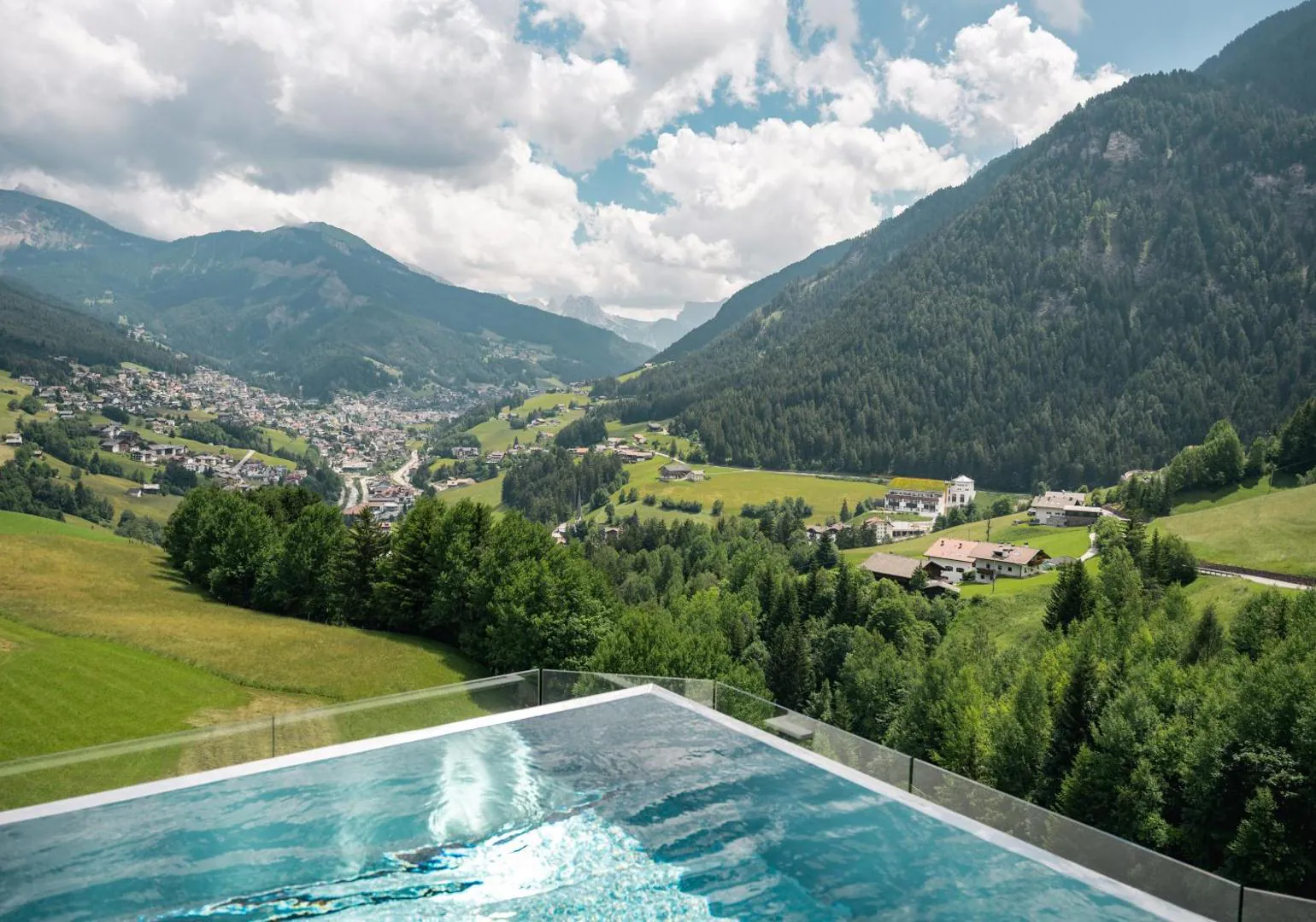 Pool edge above green meadows and the valley in summer