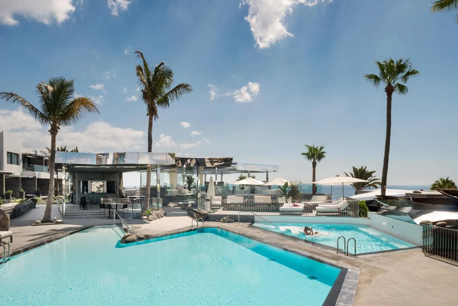 Pool below the hotel's terraces with palms and the Atlantic beyond