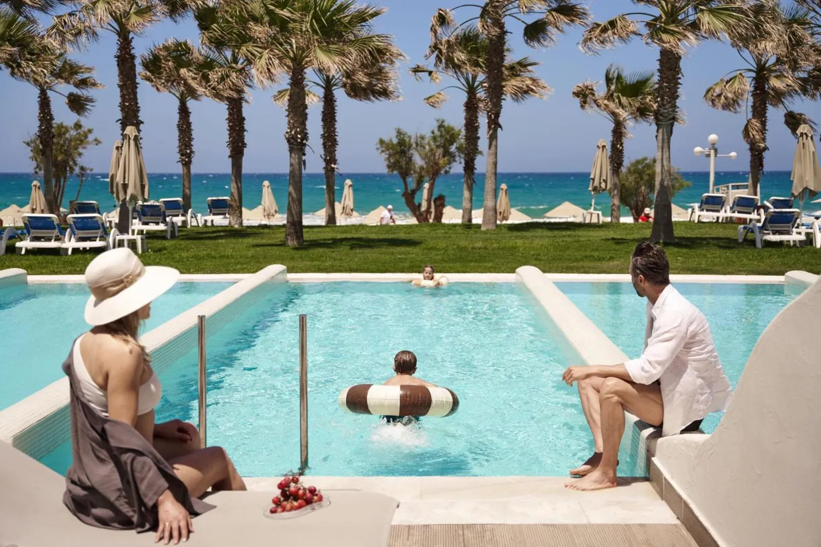 Guests in a private pool steps from the beach and its palms