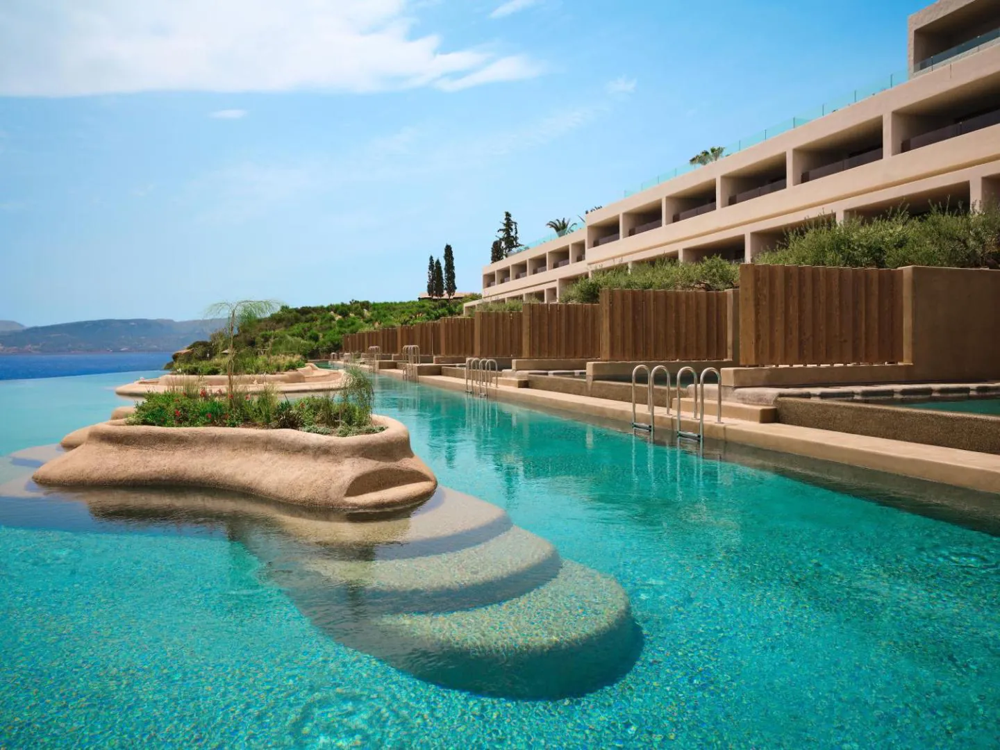 Lagoon pool running alongside the suites, with a planted island in the middle