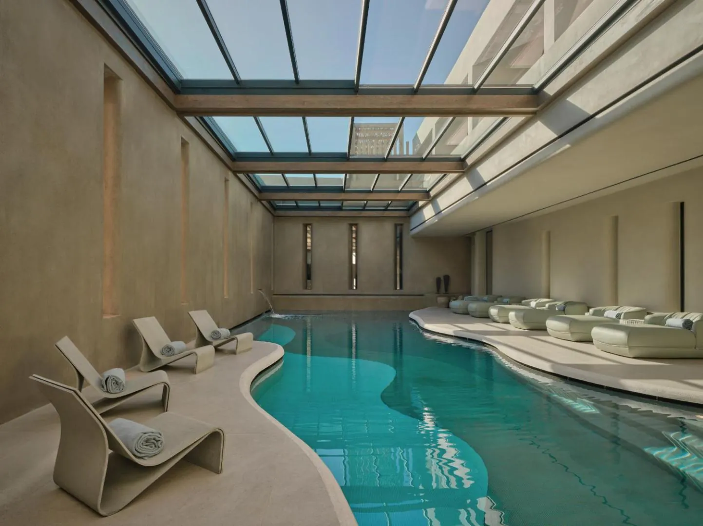 Curving indoor pool under a glass roof in the spa