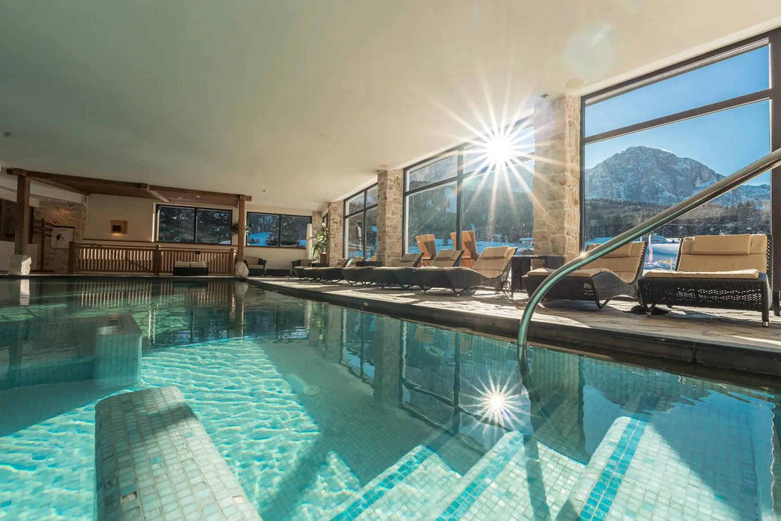 Heated indoor pool with the Sassolungo through the windows at Monte Pana Dolomites Hotel