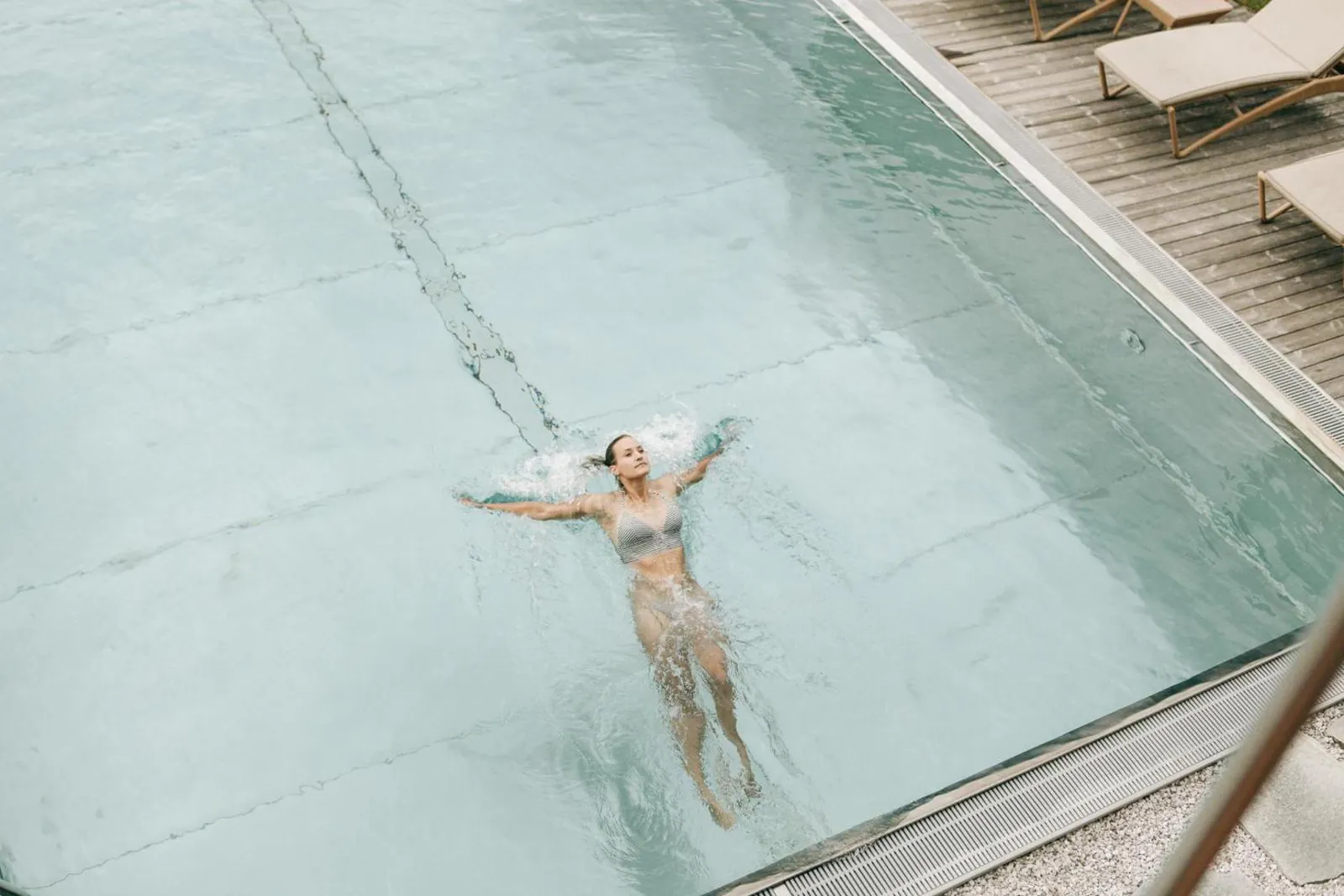 Guest floating in the outdoor pool at Naturhotel Leitlhof seen from above