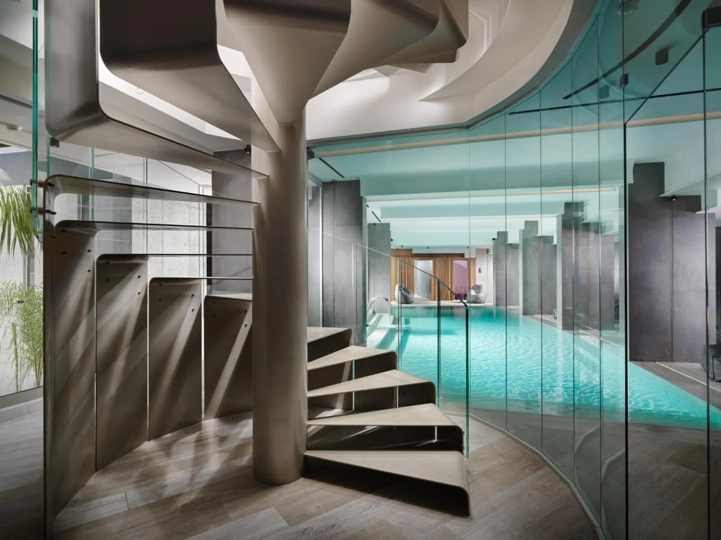 Indoor spa pool beneath a curving staircase