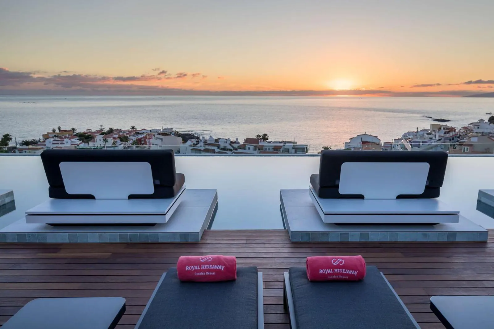 Daybeds beside the rooftop pool at sunset