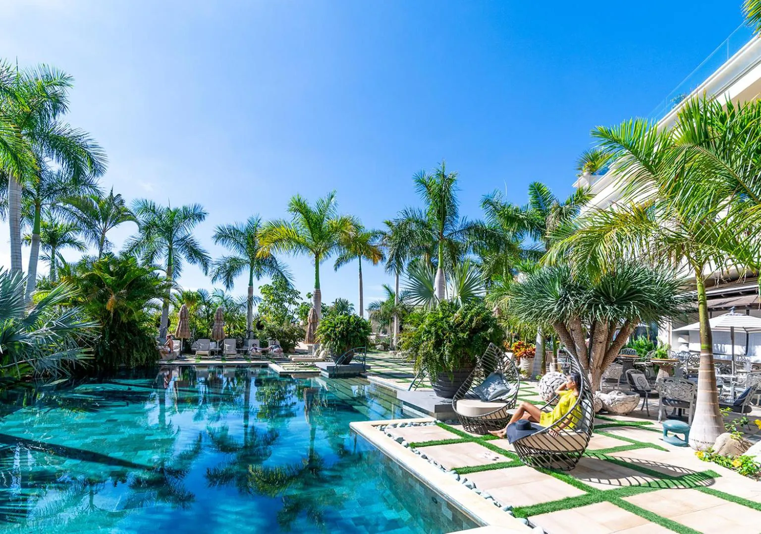 River pool winding between palms and villa terraces at Royal River