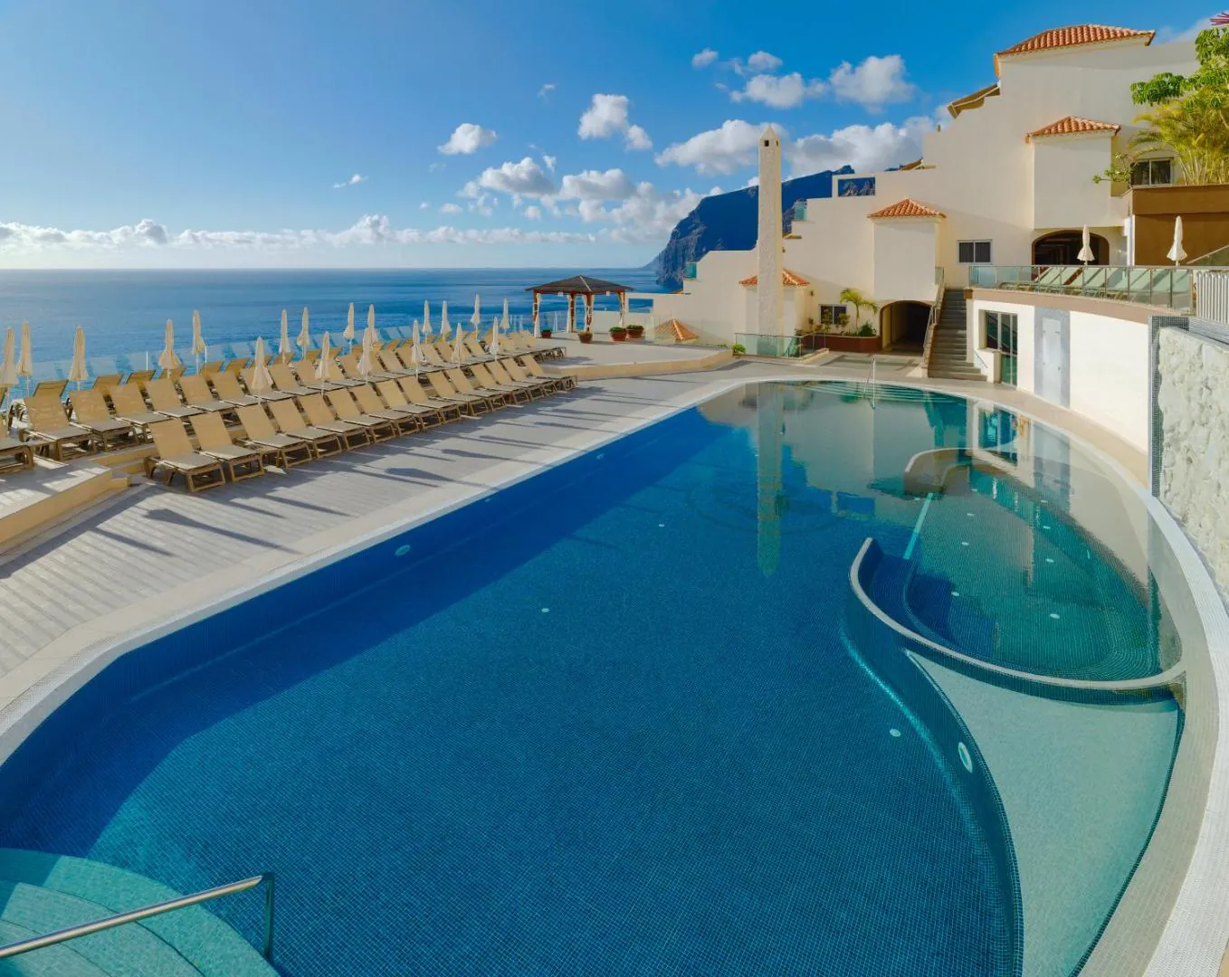 Outdoor pool and loungers with the Atlantic beyond at Royal Sun Resort