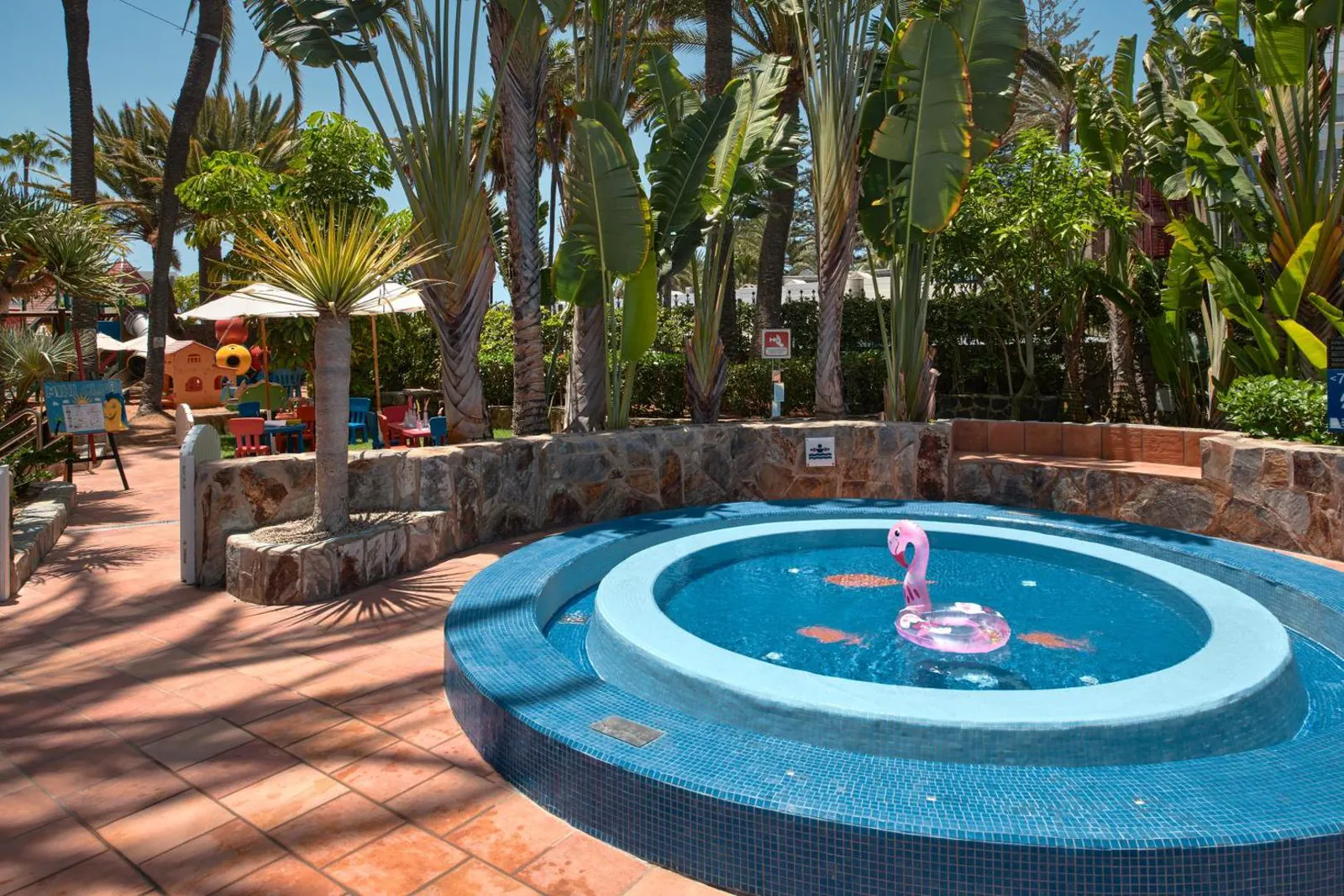Shallow round kids' pool with a fountain in the hotel garden