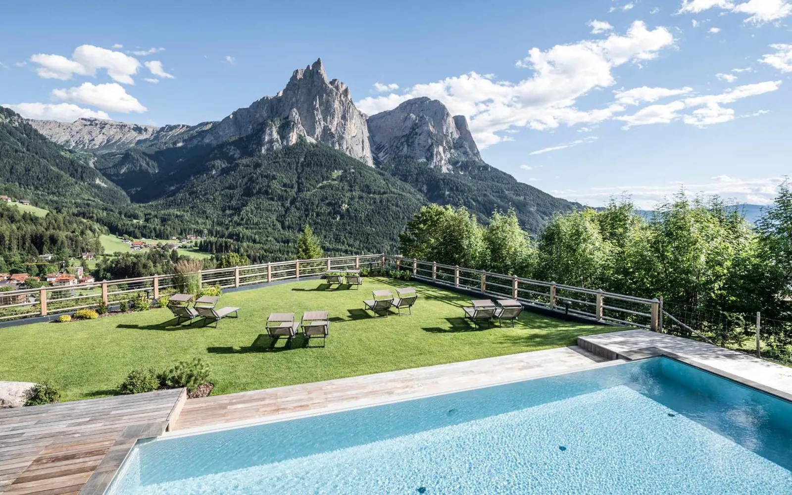 Outdoor pool and sun loungers on the lawn at Sonus Alpis, Castelrotto, facing the Sciliar