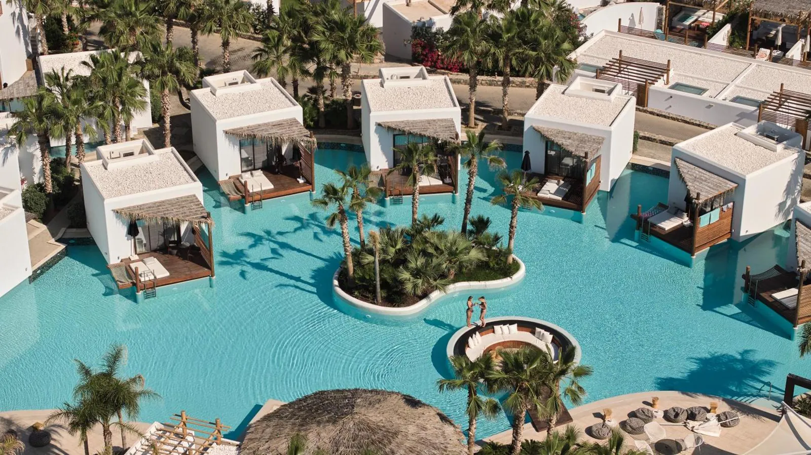 Bungalows with thatched terraces set along the lagoon pool at Stella Island