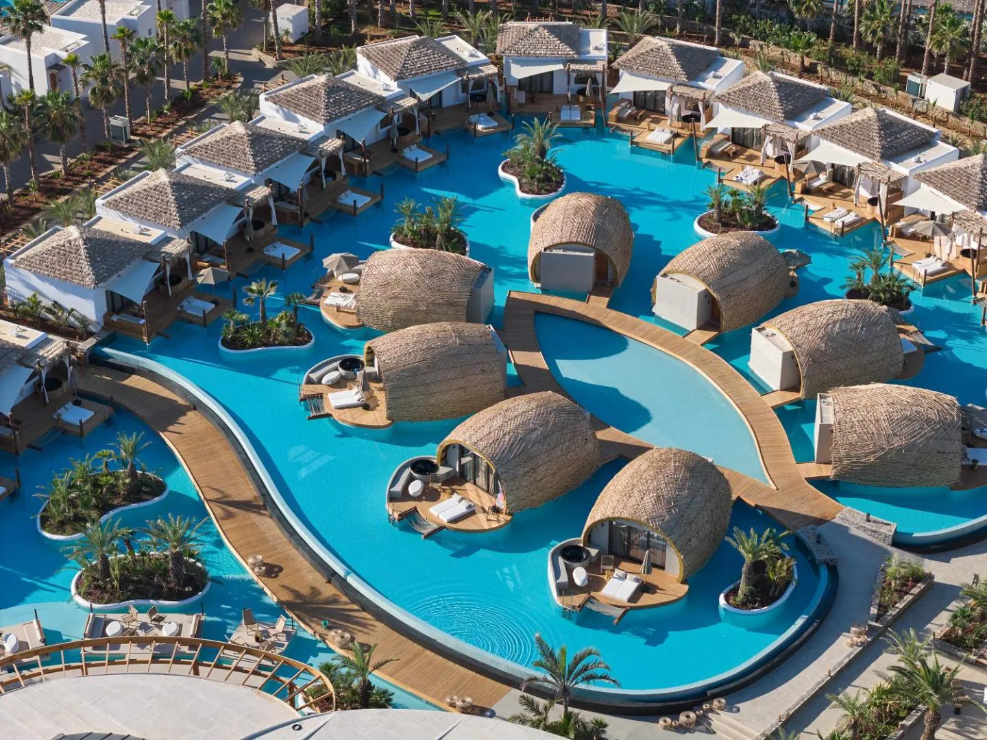 Aerial view of the lagoon pool curving between palm islands and rooms