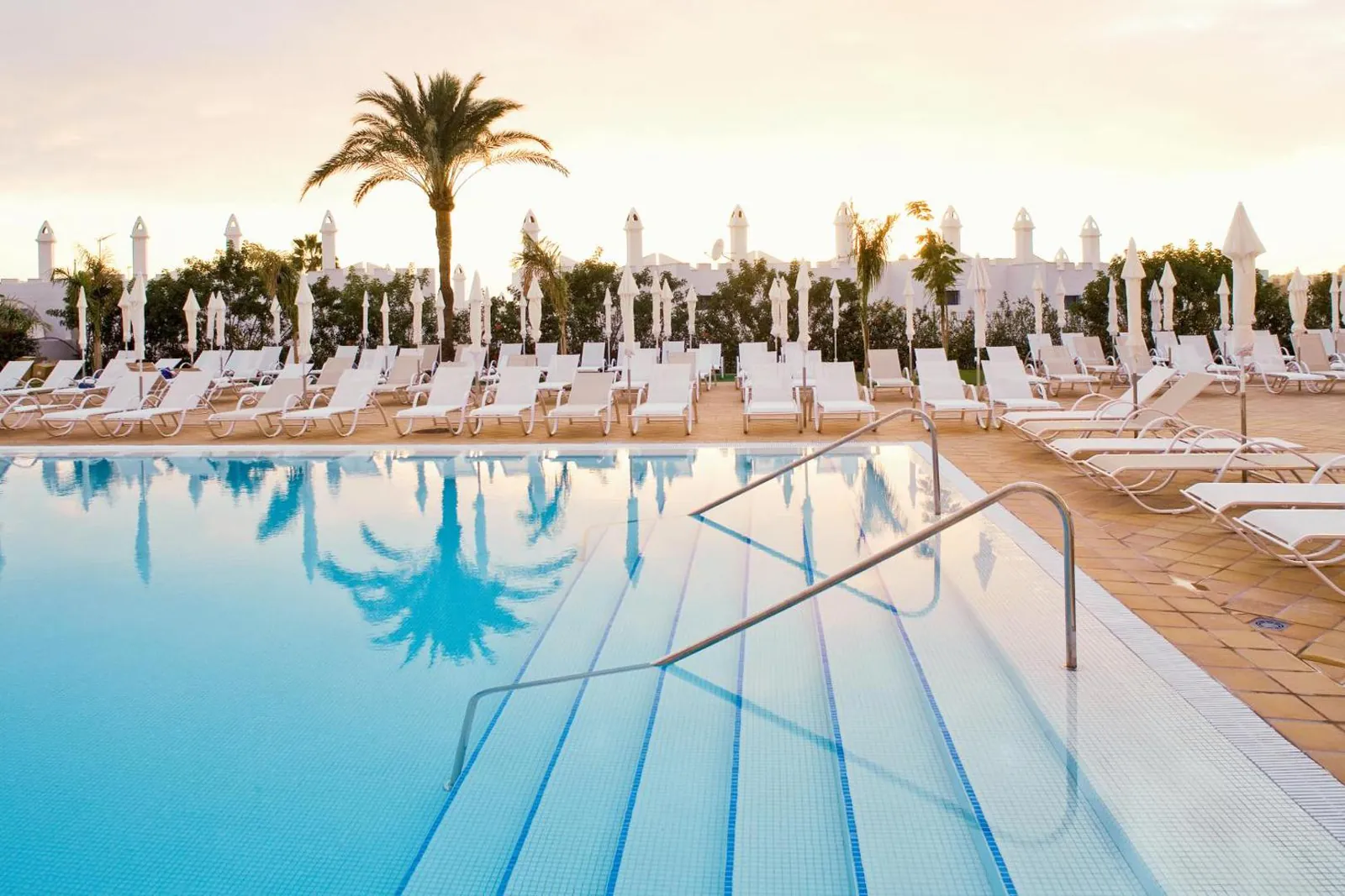 Walk-in steps into the pool with rows of white loungers