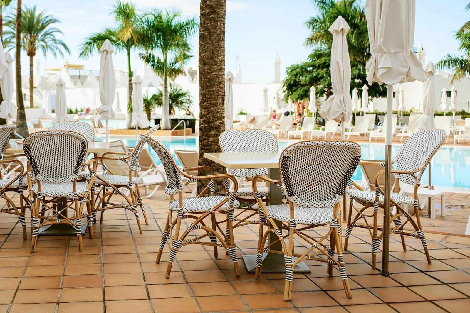 Terrace with bistro chairs next to the pool