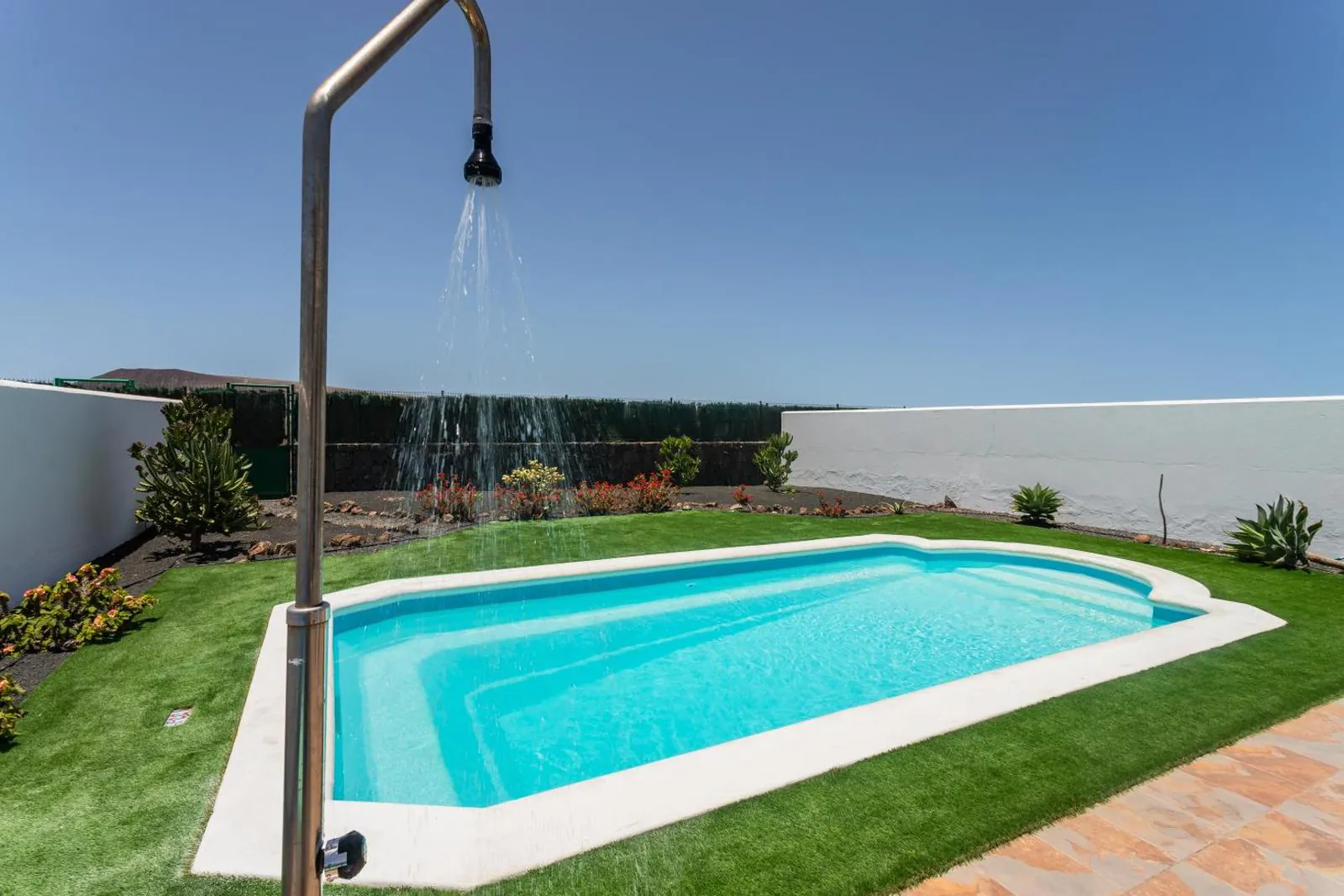 Outdoor shower beside the private pool and its lawn